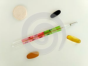 Isolated colorful mercury thermometer and green and white cannula