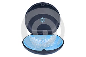 Isolated container with transparent invisalign aligner retainers or removable braces on white background photo