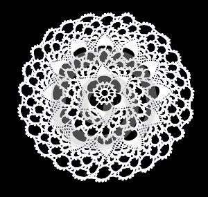 Isolated crocheted laced white doily with many picos at the egde on a black background. Round decorative cotton doily