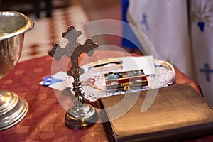 Isolated cross and bible on table. Orthodox church wedding accessories