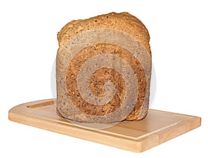 Isolated Crusty Loaf of Wholegrain Bread on Breadboard.