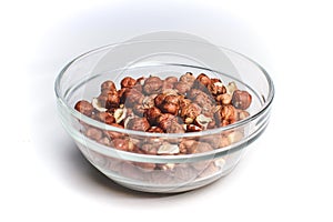 Isolated crystal bowl with hazelnuts against white background