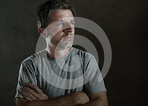 Isolated dark background portrait of 30s to 40s sad and depressed man looking thoughtful and worried suffering depression problem