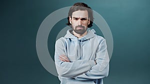 Isolated Dark-haired guy confused feels doubt while makes choice, dressed in casual hoodie