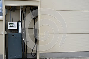 Isolated diesel filling station situated in the wall of cream colour industrial building.