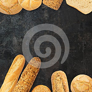 Isolated different kinds of bread on a black background. Photo of variety of bread with copy space. Top view. Related to bakery