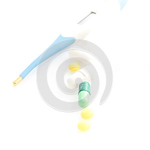 Isolated Digital Thermometer with pills on white background