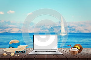 Isolated display of laptop on wooden table for mockup. Sea, yacht and blue sky in background.