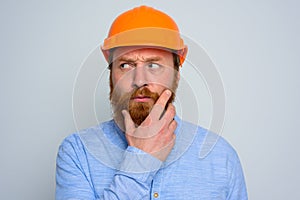 Isolated doubter architect with beard and orange helmet