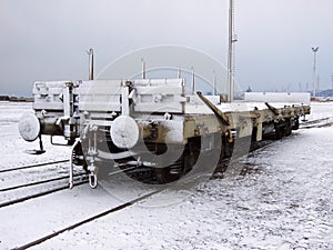 An isolated empty freight wagon covered with snow