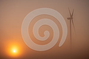 Isolated eolian mill , misty morning sunrise in summer time