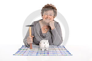 Isolated female pensioner killing her piggy bank.