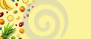 Isolated flat top view of different types of fruits on a soft yellow background with copy space. Concept of healthy, organic,