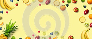 Isolated flat top view of different types of fruits on a soft yellow background with copy space. Concept of healthy, organic,