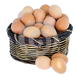 Isolated fresh eggs in wooden basket.