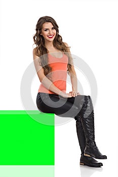 Isolated Girl Sitting On Green Chroma Key Box