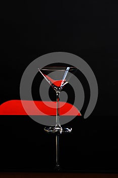 An isolated glass for martini on dark and red background. Cocktail