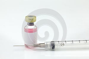 Isolated glass vaccine bottle with colored liquid and syringe very close high magnification mockup