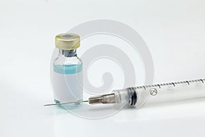 Isolated glass vaccine bottle with colored liquid and syringe very close high magnification mockup