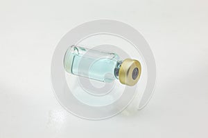 Isolated glass vaccine bottle lying down with colored liquid very close high magnification mockup