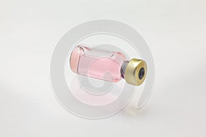 Isolated glass vaccine bottle lying down with colored liquid very close high magnification mockup