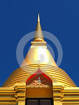 Isolated golden stupa soars into blue sky