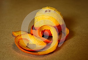 Isolated half peeled  orange. spiraling peeled skin