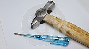 Isolated hammer and a line tester placed over white background. Engineering tools