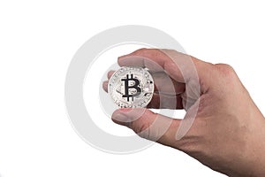 Isolated hand holding a golden bitcoin with finger tip on white