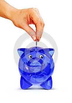 Isolated hand putting coin into piggy bank