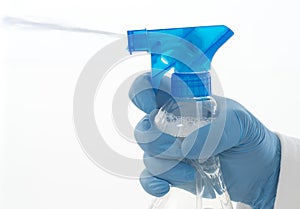 Isolated hand wearing cleaning glove holding a spray bottle