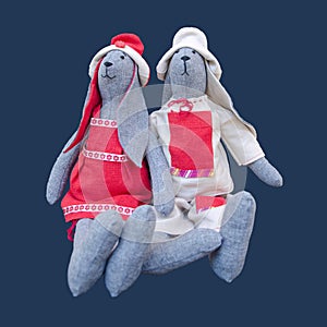 Isolated handmade dolls bunny family in homespun clothing sitting