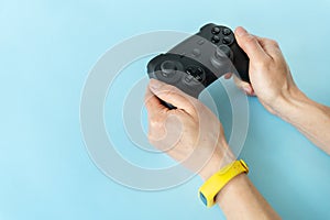 Isolated hands on a blue background that hold a joystick. Young gamer, game, recreation, competition