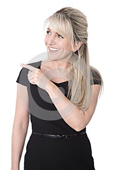 Isolated happy business woman in black pointing at text.