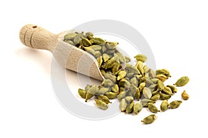 Isolated heap of cardamom seeds in a wooden scoop