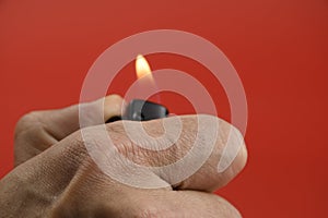 Hand lighting a lighter. Close view of hand and fire. photo