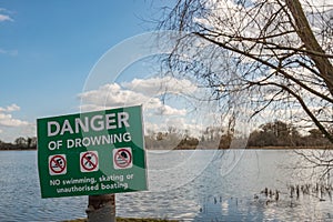 Isolated image of a Danger Sign seen positioned near a deep, open river and adjacent quick sands.