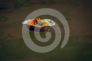 Isolated image of a floating lamp with flowers and candle offered to holy river Ganges at Varanasi Ghats photo