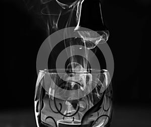 Isolated image of a glass filled with fog-like smoke isolated on black background