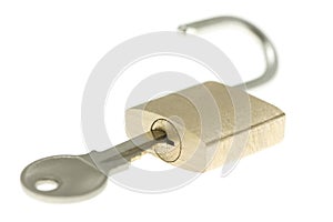 Isolated just-opened brass padlock with key