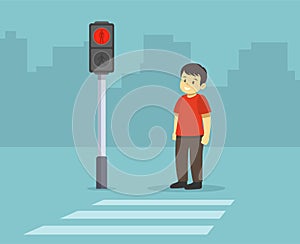 Isolated kid waiting green light of the traffic light at pedestrian crossing.