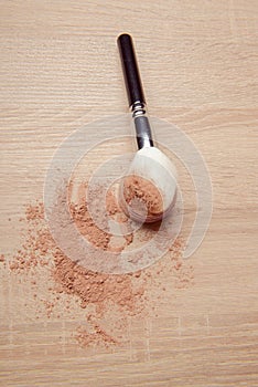 Isolated make-up powder with brush on woodenbackground