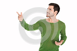 Isolated man in green pullover pointing and looking sideways to photo