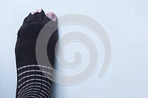 Isolated mans toes poking out of the holes socks