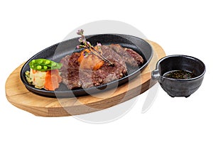 Isolated medium rare wagyu steak topping with mince carrot on hot plate and wooden plate served with potato salad with ponzu sauce