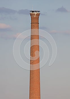 Isolated old aged weathered tall industrial factory chimney
