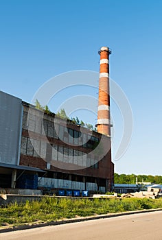Isolated old aged weathered tall industrial factory chimney, red grungy brick smokestack grunge vintage