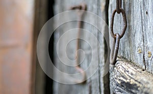 Isolated old rusty door latch on a wooden door. Close-up. Problematic weathered panels. Old wall texture background. Detail of an