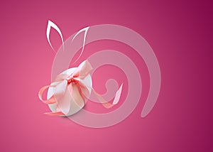 Isolated one easter white egg with pink ribbon with painted Bunny rabbit ears on burgundy background with copy space.