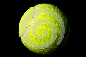 Isolated Optic Yellow Tennis Ball on Black Backdrop